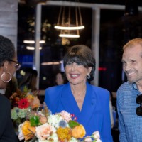 GVSU President smiles at women at a table with a man